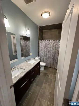 a bathroom with a double vanity sink toilet and shower
