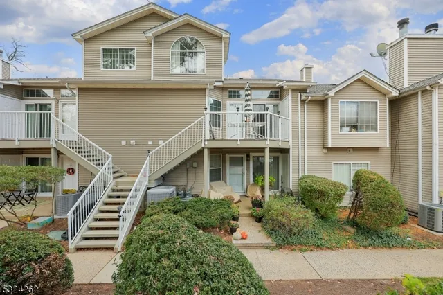 a front view of a house with a yard and potted plants