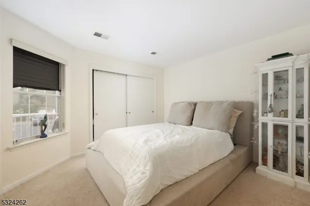 a large bed sitting in a bedroom next to a window