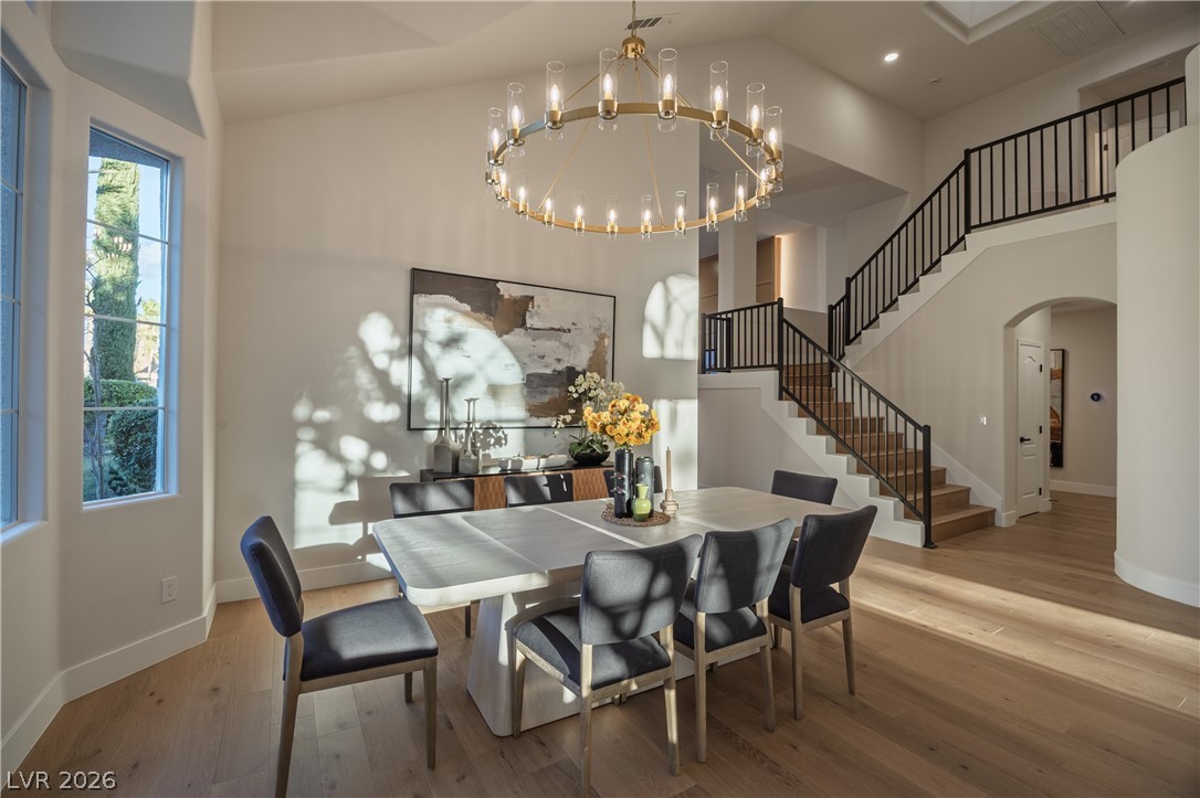 8800 Lusso Las Vegas, NV 89134 - Photo 22 of 85 Dining space featuring arched walkways, hardwood / wood-style floors, suspended lighting, and a high ceiling