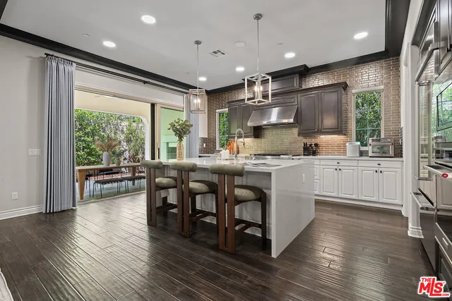 a kitchen with counter top space a sink appliances and living room view