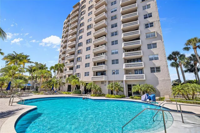 a kitchen with stainless steel appliances kitchen island a table chairs in it and wooden floors