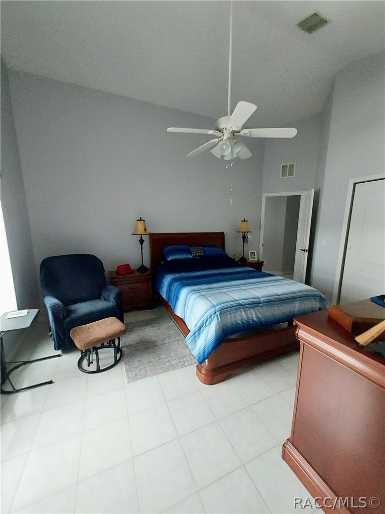 9306 East Gospel Island Road Inverness, FL 34450 - Photo 9 of 16 a bedroom with a bed gym equipment and a chandelier