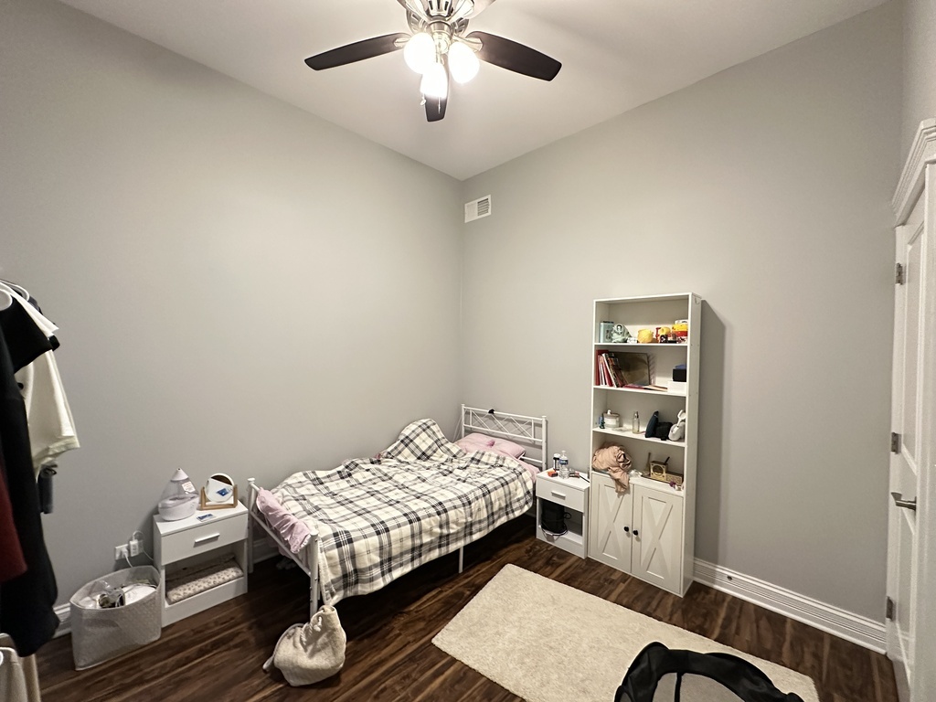 3336 West Irving Park Road, Unit 1 Chicago, IL 60618 - Photo 15 of 20 a bedroom with a bed and a chandelier