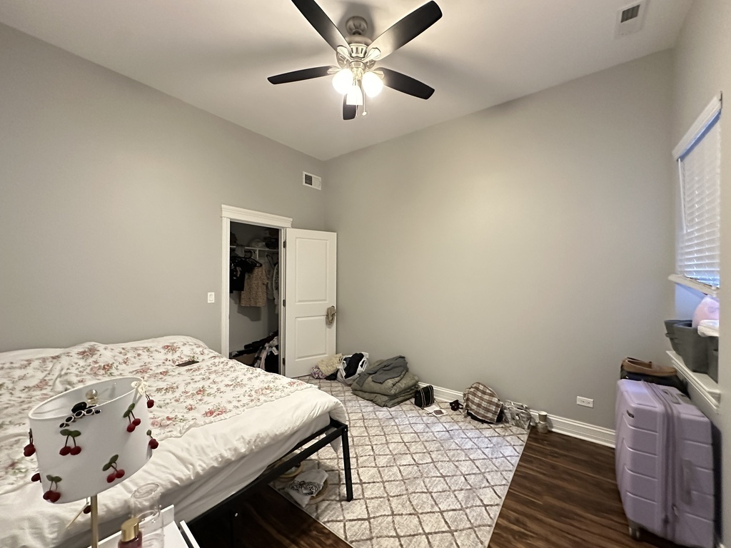 3336 West Irving Park Road, Unit 1 Chicago, IL 60618 - Photo 17 of 20 a bedroom with a bed and a chandelier