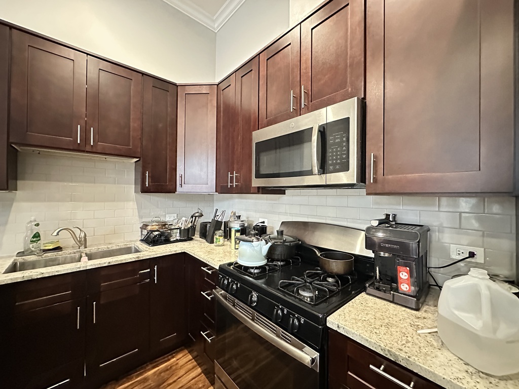3336 West Irving Park Road, Unit 1 Chicago, IL 60618 - Photo 5 of 20 a kitchen with a sink a stove and cabinets