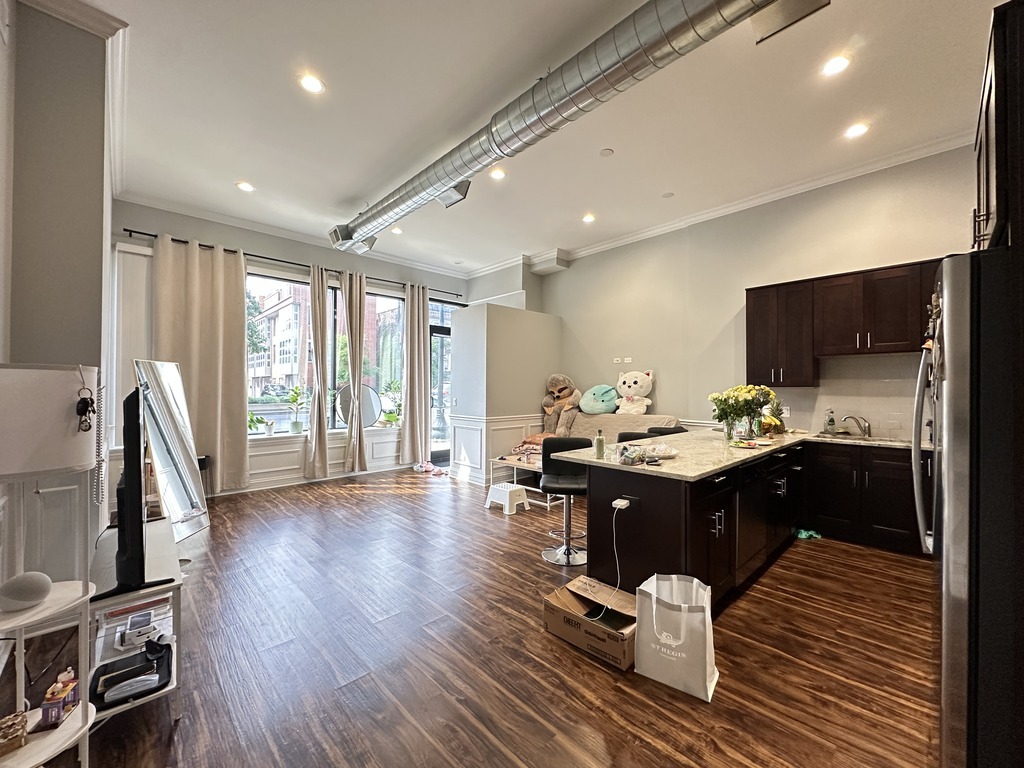 3336 West Irving Park Road, Unit 1 Chicago, IL 60618 - Photo 8 of 20 a living room with furniture flat screen tv and kitchen view