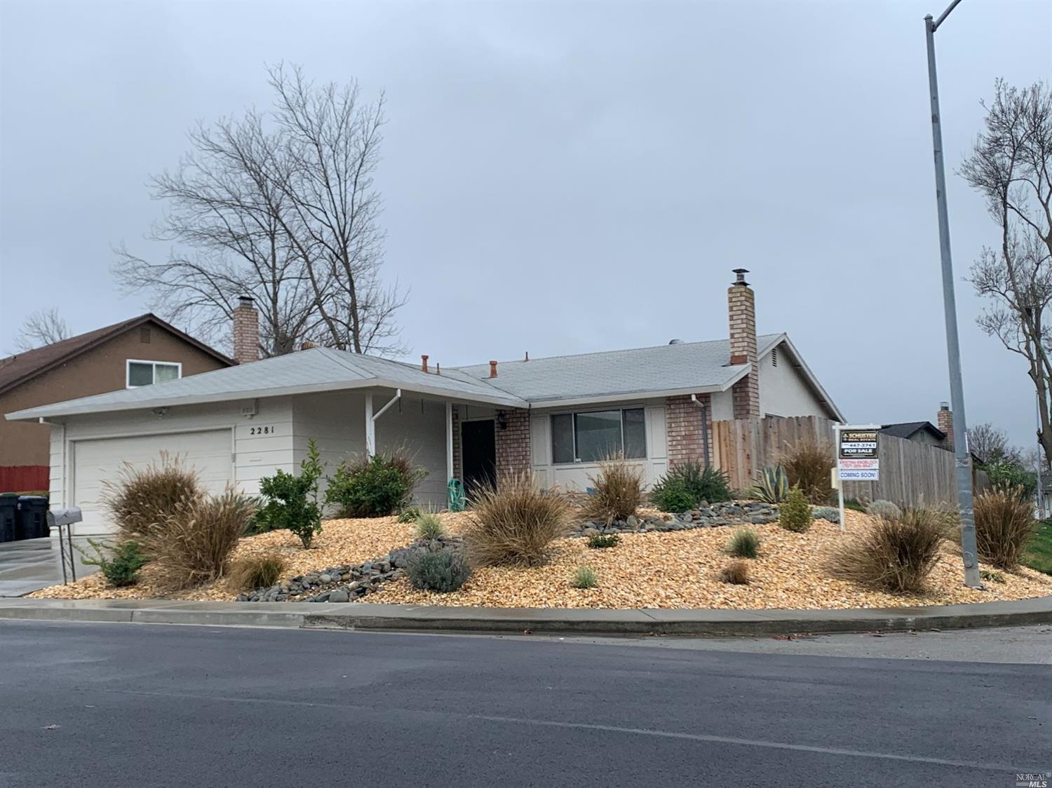 a front view of a house with a yard and potted plants