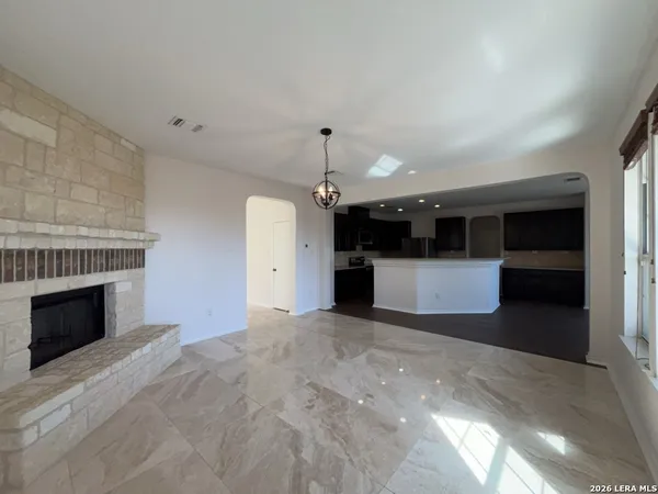 a view of a kitchen with kitchen island a sink wooden floor and a living room view