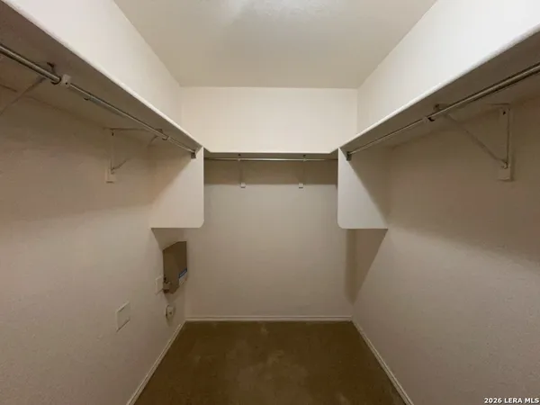 an empty room with windows and chandelier fan