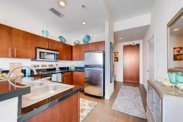 a kitchen with stainless steel appliances granite countertop a sink stove and microwave
