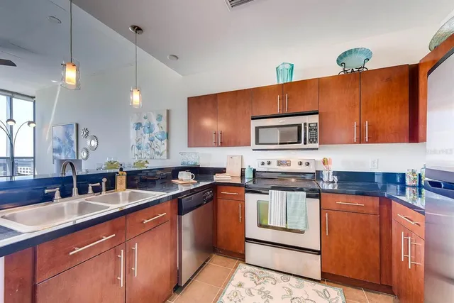 a kitchen with stainless steel appliances granite countertop stove a sink dishwasher and microwave oven with wooden floor