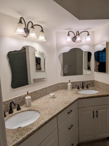a bathroom with double vanity sinks and a mirror