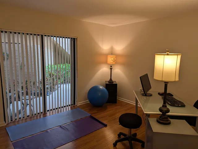 a view of a workspace with furniture and a window
