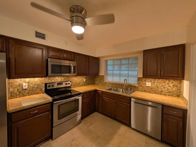a kitchen with stainless steel appliances granite countertop a sink and stove top oven