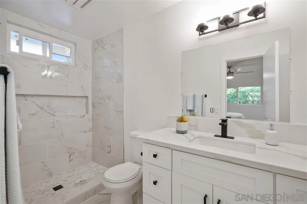 751 Crestview Road Vista, CA 92081 - Photo 16 of 24 a bathroom with a double vanity sink toilet and shower