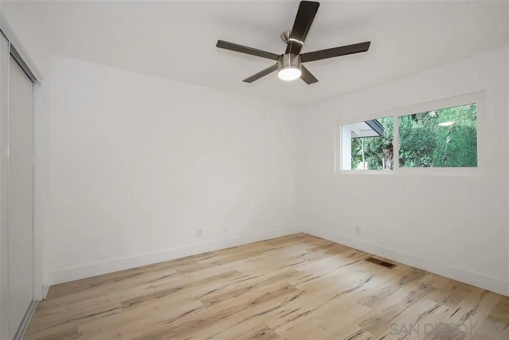 751 Crestview Road Vista, CA 92081 - Photo 19 of 24 an empty room with wooden floor fan and windows