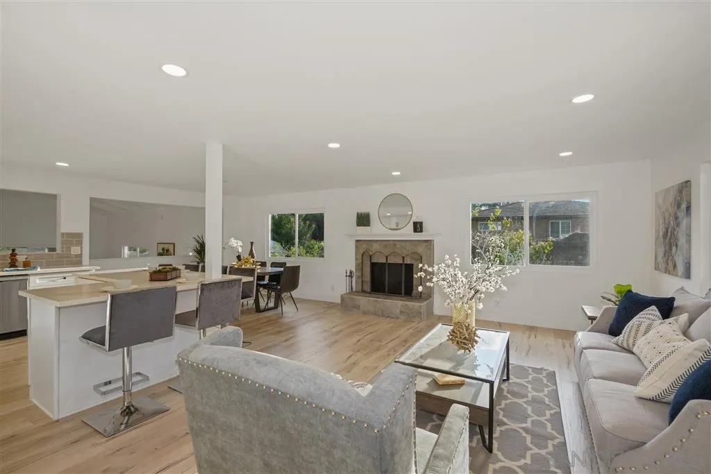 751 Crestview Road Vista, CA 92081 - Photo 7 of 24 a living room with furniture a fireplace and a dining table with wooden floor