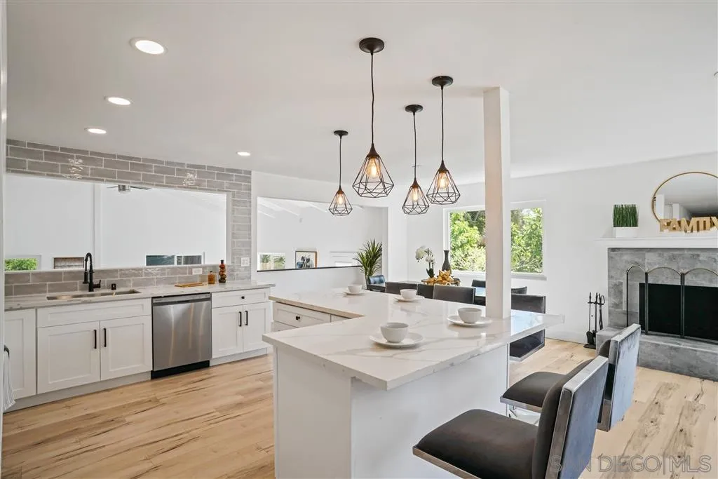751 Crestview Road Vista, CA 92081 - Photo 9 of 24 a large kitchen with kitchen island a stove a sink a counter space and living room view