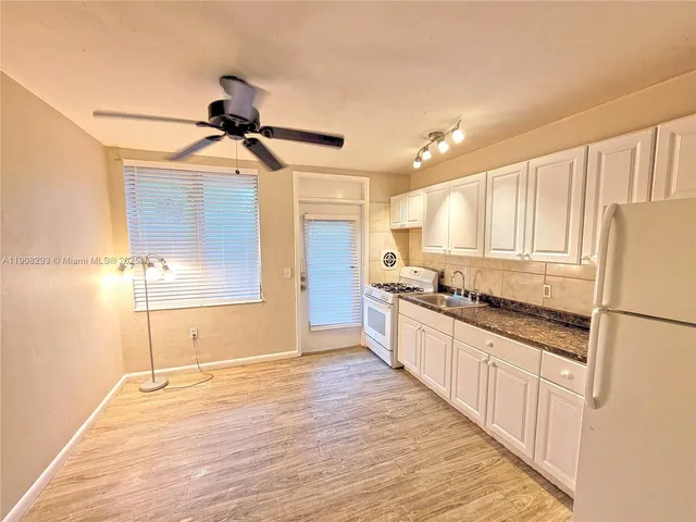 a large kitchen with cabinets wooden floor and stainless steel appliances