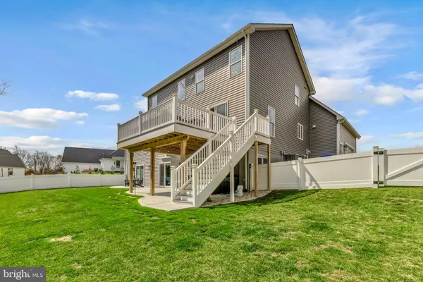 a view of a yard in front of a house with large trees