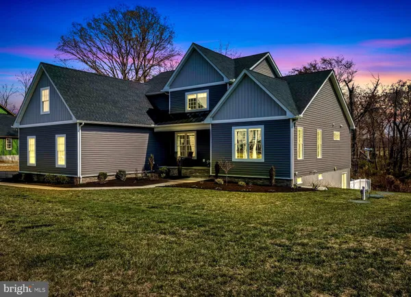 a front view of a house with a yard and trees
