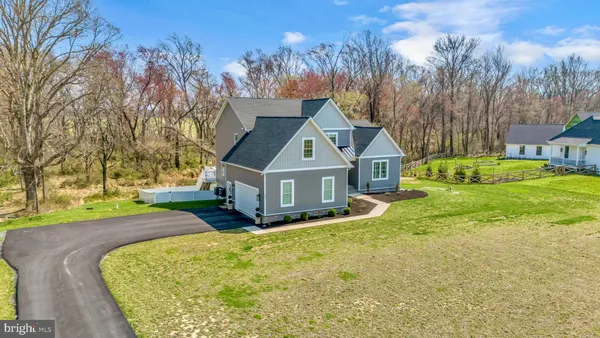 a view of a house with a big yard and a large tree