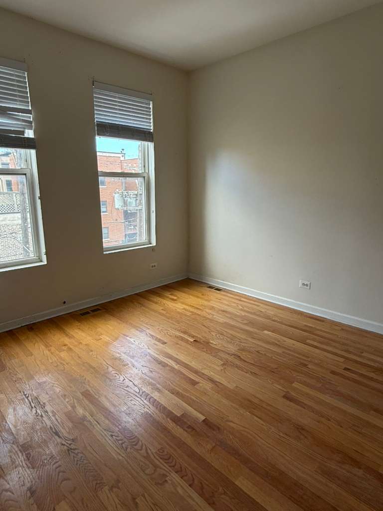 448 North Aberdeen Street, Unit 3 Chicago, IL 60642 - Photo 8 of 15 an empty room with wooden floor and windows
