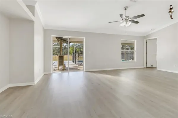 a view of an empty room with a window and wooden floor