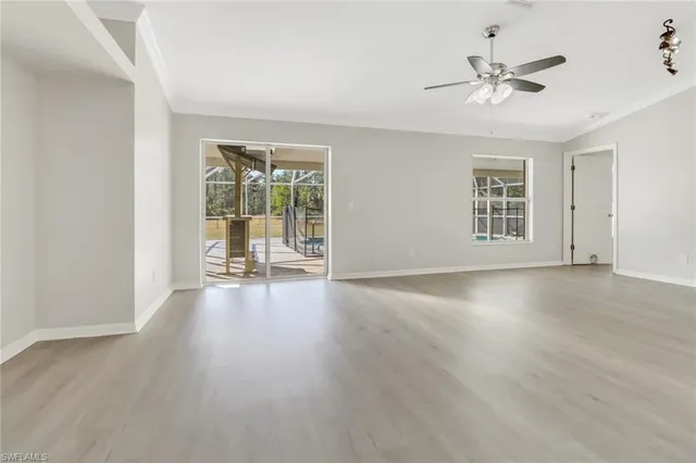 a view of an empty room with a window and wooden floor