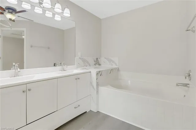 a spacious bathroom with a double vanity sink mirror and bathtub