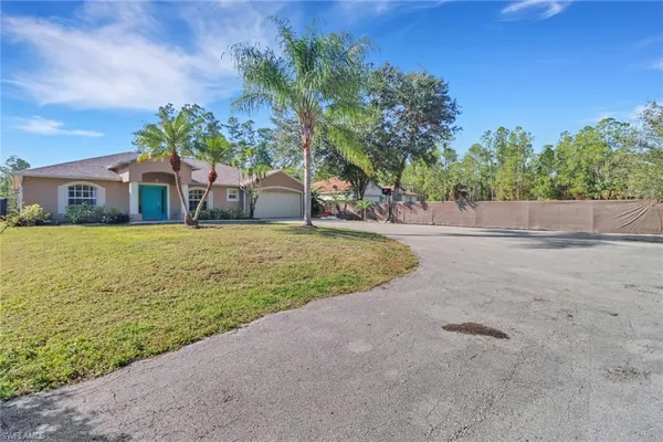 a view of a house with a yard and a garage