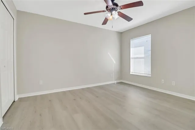 an empty room with a window and a fan