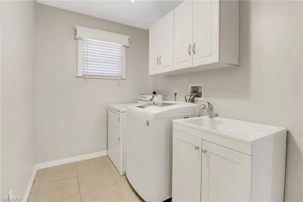 a utility room with sink dryer and washer