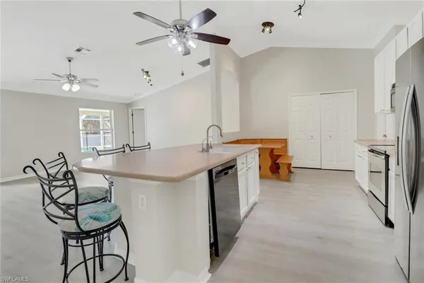 a kitchen with stainless steel appliances a table and chairs