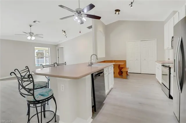 a kitchen with stainless steel appliances a table and chairs