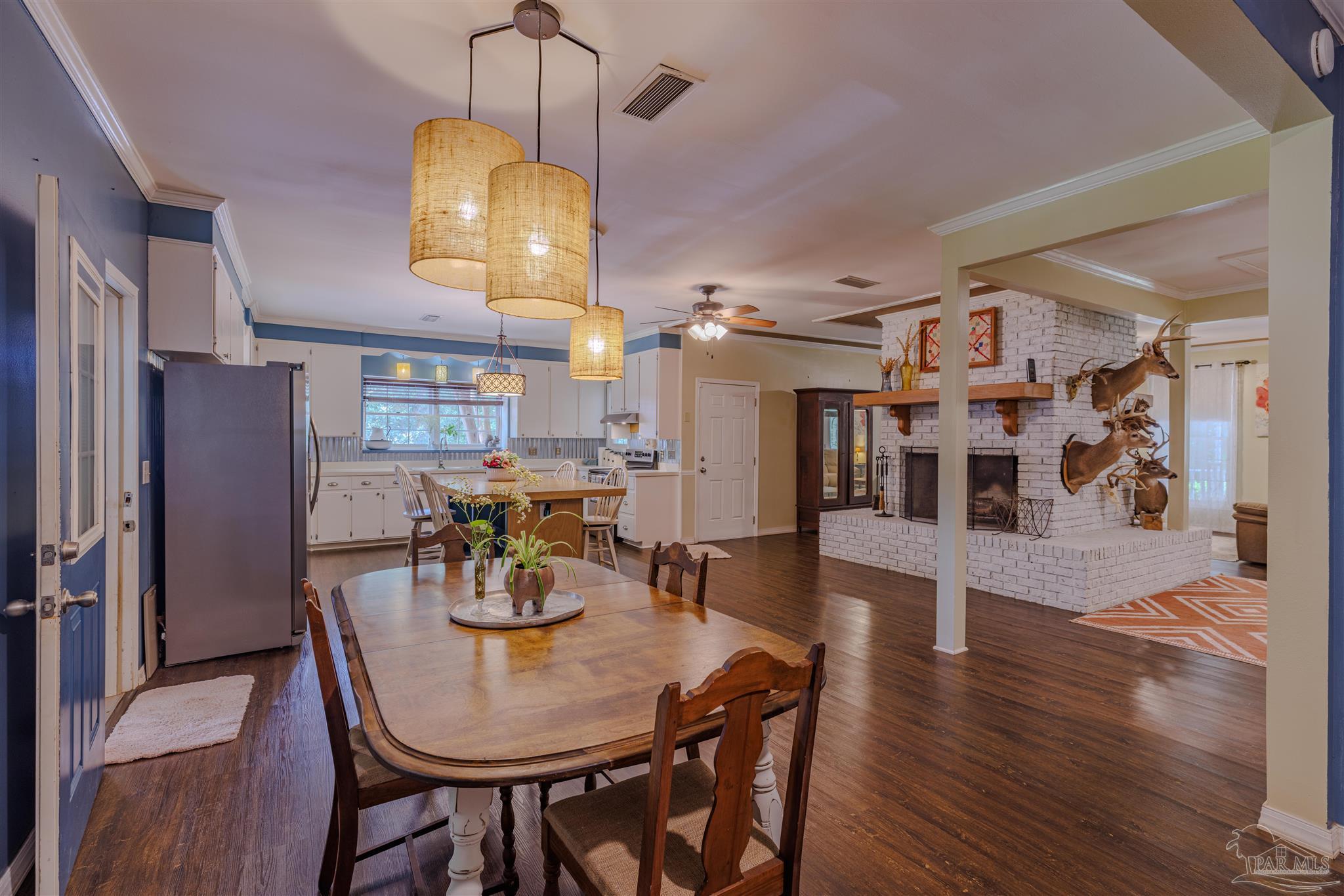 5049 Guernsey Road Pace, FL 32571 - Photo 30 of 61 a view of a dining room with furniture wooden floor and chandelier