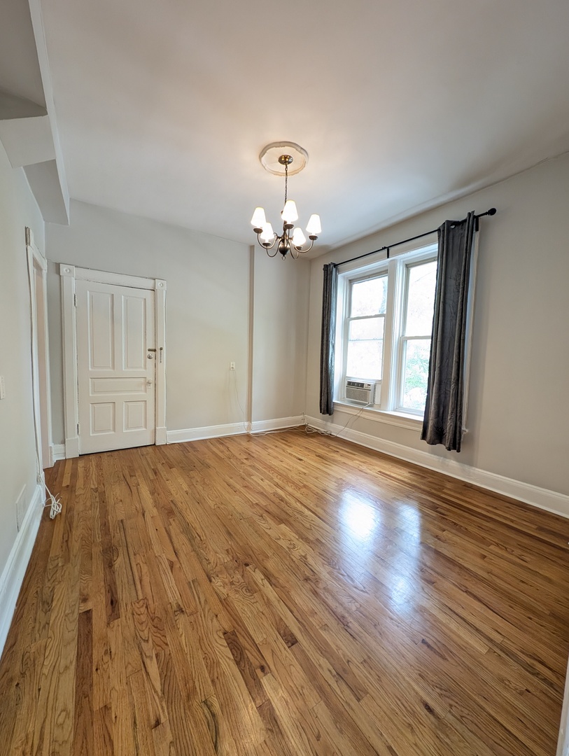 2611 West George Street, Unit 2R Chicago, IL 60618 - Photo 3 of 14 a view of an empty room with wooden floor and a window
