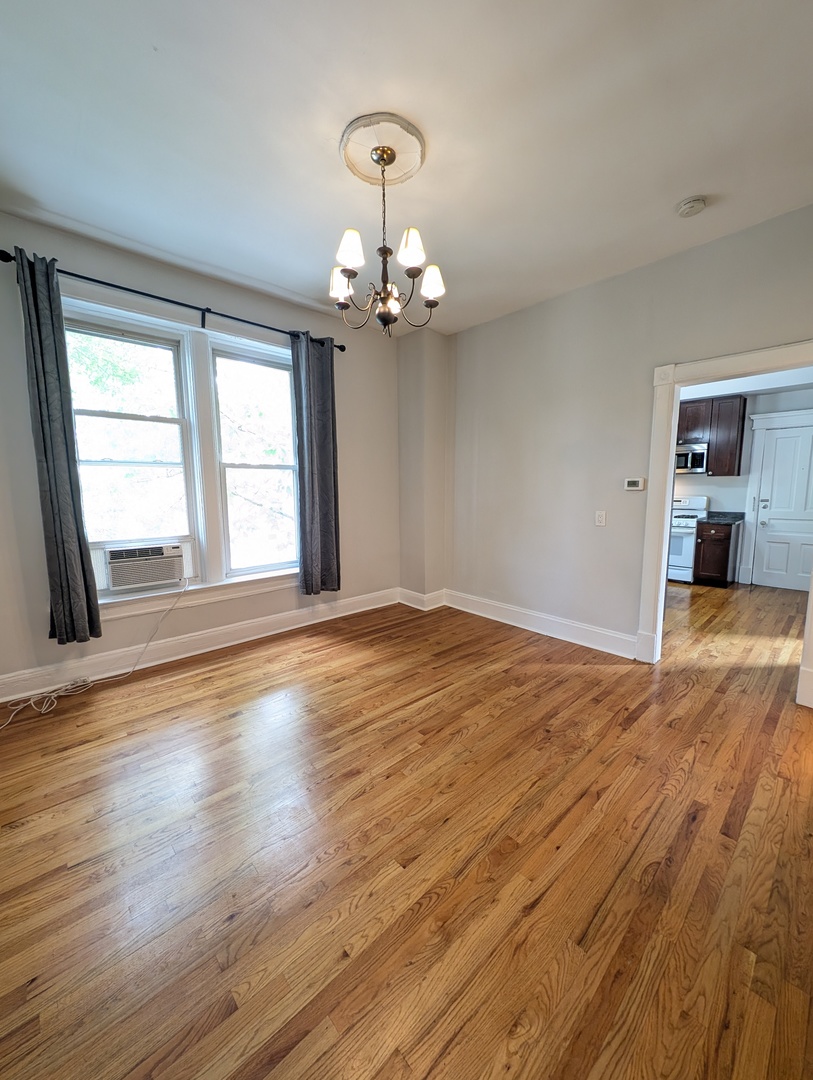 2611 West George Street, Unit 2R Chicago, IL 60618 - Photo 4 of 14 a view of empty room with wooden floor and fan