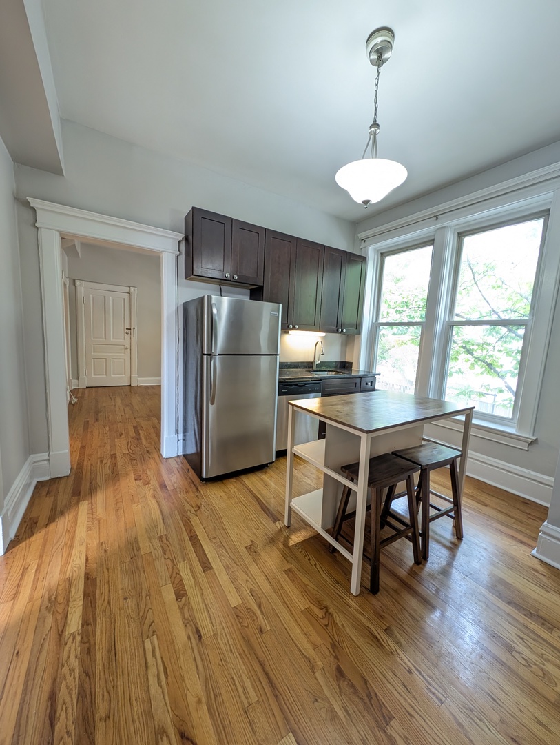 2611 West George Street, Unit 2R Chicago, IL 60618 - Photo 7 of 14 a kitchen with stainless steel appliances a dining table chairs and wooden floor
