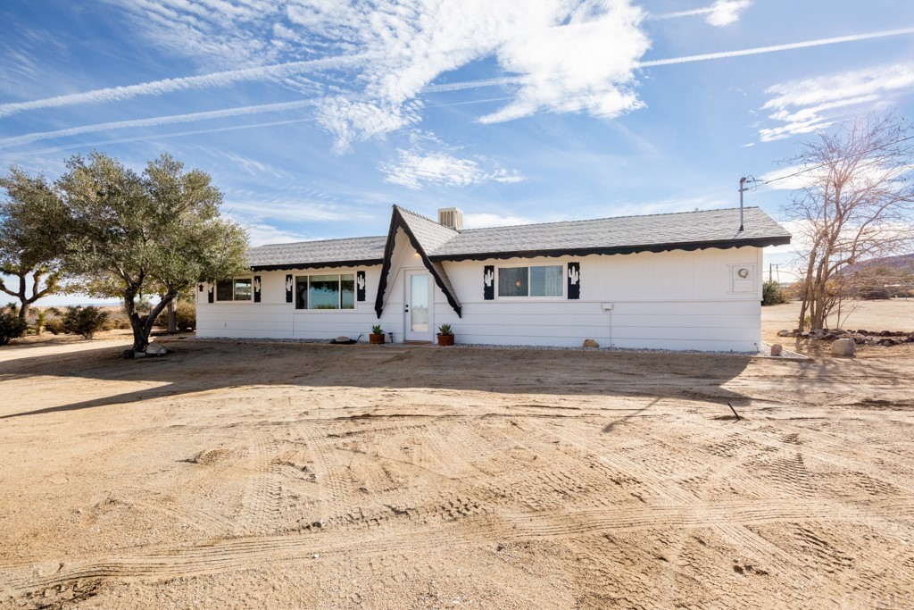 55723 Tanager Road Yucca Valley, CA 92284 - Photo 1 of 1 a view of a white house with a yard