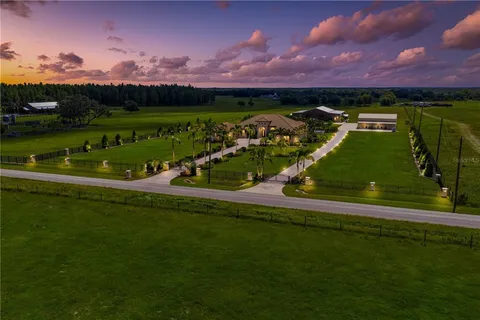 a kitchen with stainless steel appliances kitchen island granite countertop a dining table chairs and white cabinets