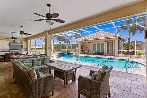 a living room with furniture a ceiling fan and a flat screen tv