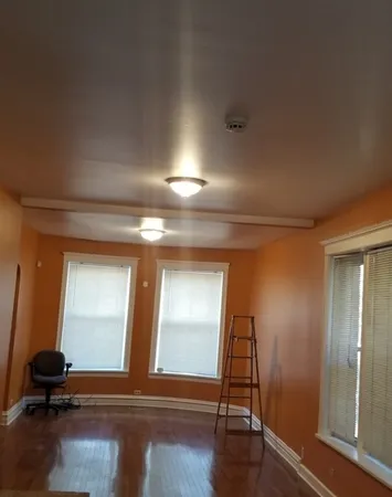 a room with gym equipment and wooden floor