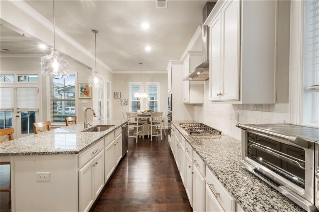 313 Senna Street Marietta, GA 30064 - Photo 17 of 43 a kitchen with granite countertop kitchen island wooden cabinets stainless steel appliances a sink and a counter top space