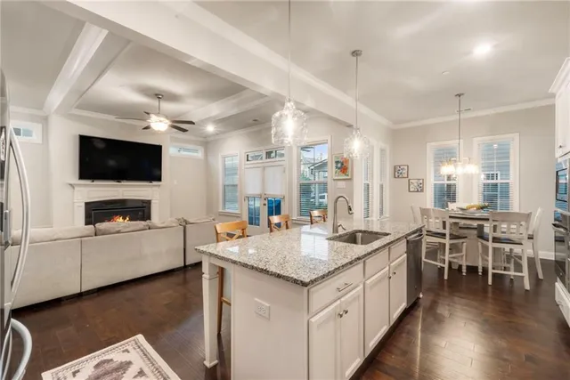 a kitchen with granite countertop a sink a stove and cabinets