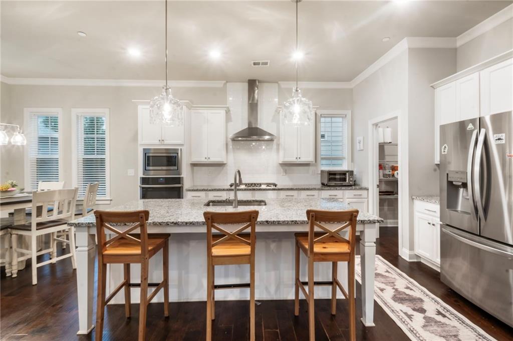 313 Senna Street Marietta, GA 30064 - Photo 20 of 43 a kitchen with stainless steel appliances granite countertop a stove a refrigerator a kitchen island a table and chairs