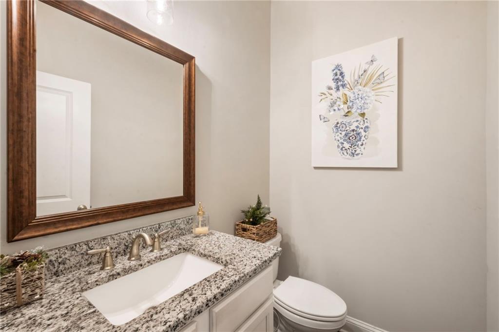 313 Senna Street Marietta, GA 30064 - Photo 23 of 43 a bathroom with a granite countertop toilet a sink and a mirror