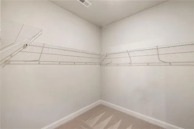 a view of walk in closet with clothes