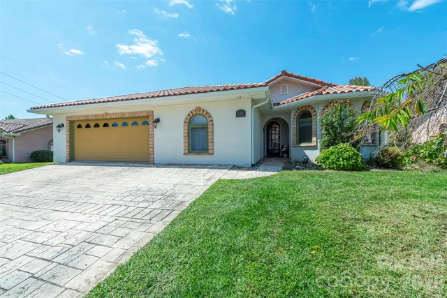 a front view of a house with a garden and yard